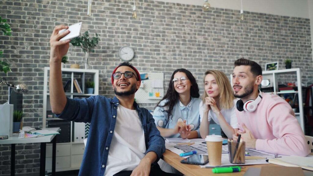 Grupo de estudantes tirando selfie durante intercâmbio, representando como aprender inglês rápido com imersão cultural no exterior.