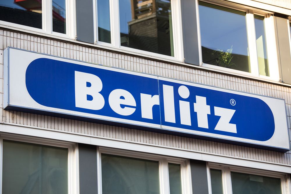 Fachada de uma loja com placa azul e branco com o nome Berlitz, empresa que atua no ramo de ensino de idiomas no Brasil e no exterior.